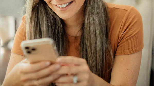 Hands holding phone, one thumb scrolling.